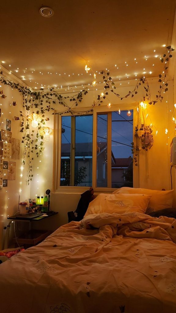 aesthetic day in my life story person holding a cup of tea in bed with fairy lights